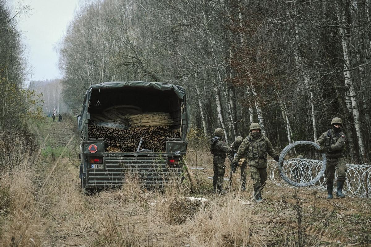 Soldados del ejército polaco arreglan bobinas de alambre de púas en una valla a lo largo de la frontera polaca, con el enclave ruso de Kaliningrado, cerca de Zerdziny, Polonia