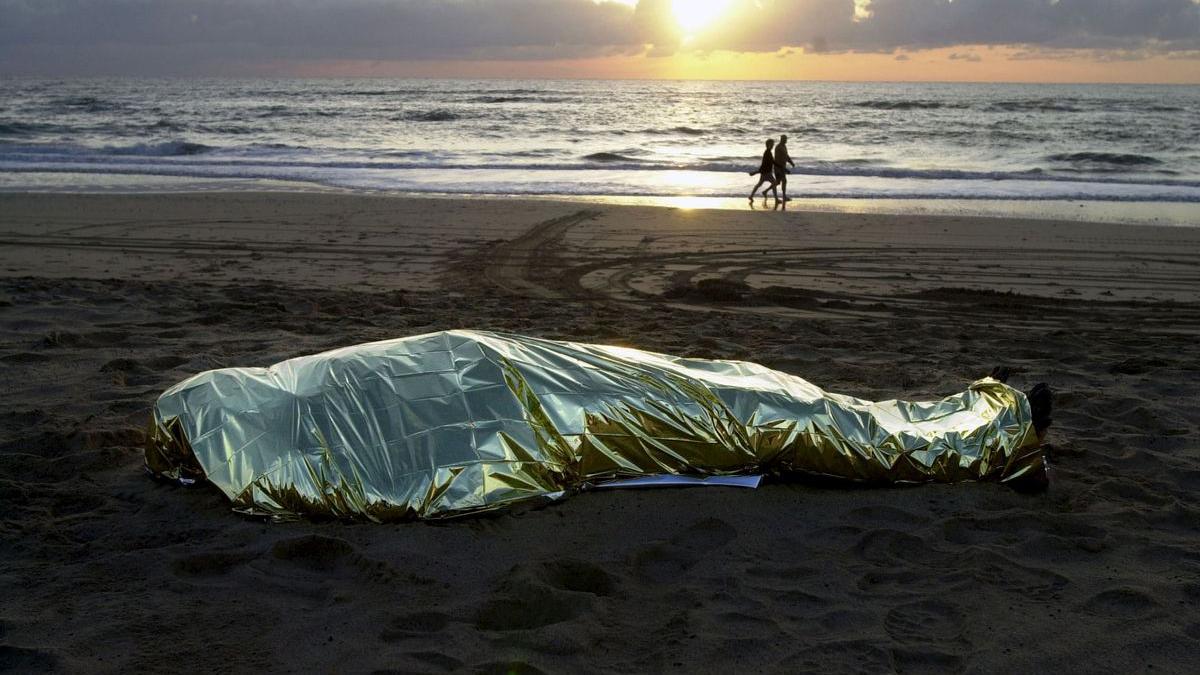El cuerpo de un migrante fallecido en un naufragio en el mar yace en una playa de Fuerteventura.