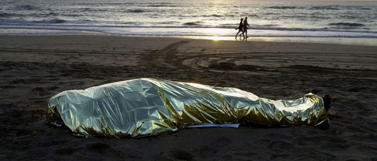 El cuerpo de un migrante fallecido en un naufragio en el mar yace en una playa de Fuerteventura.