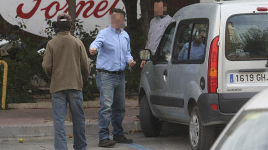 Un conductor entrega unas monedas a Carlos, uno de los aparcacoches que ejercen en la zona del seminario