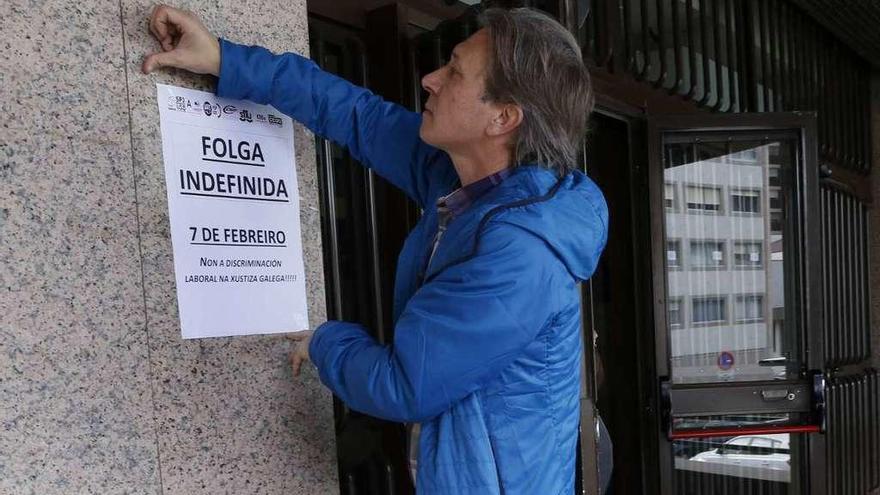 Un representante sindical, ayer, colgando carteles relativos al paro indefinido. // Ricardo Grobas