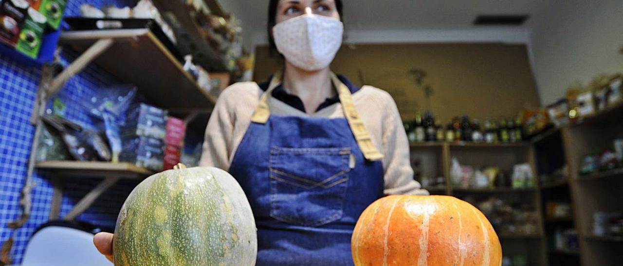 Montse Fernández, muestra dos calabazas en su tienda del Novo Mercado. | // BERNABÉ/JAVIER LALÍN