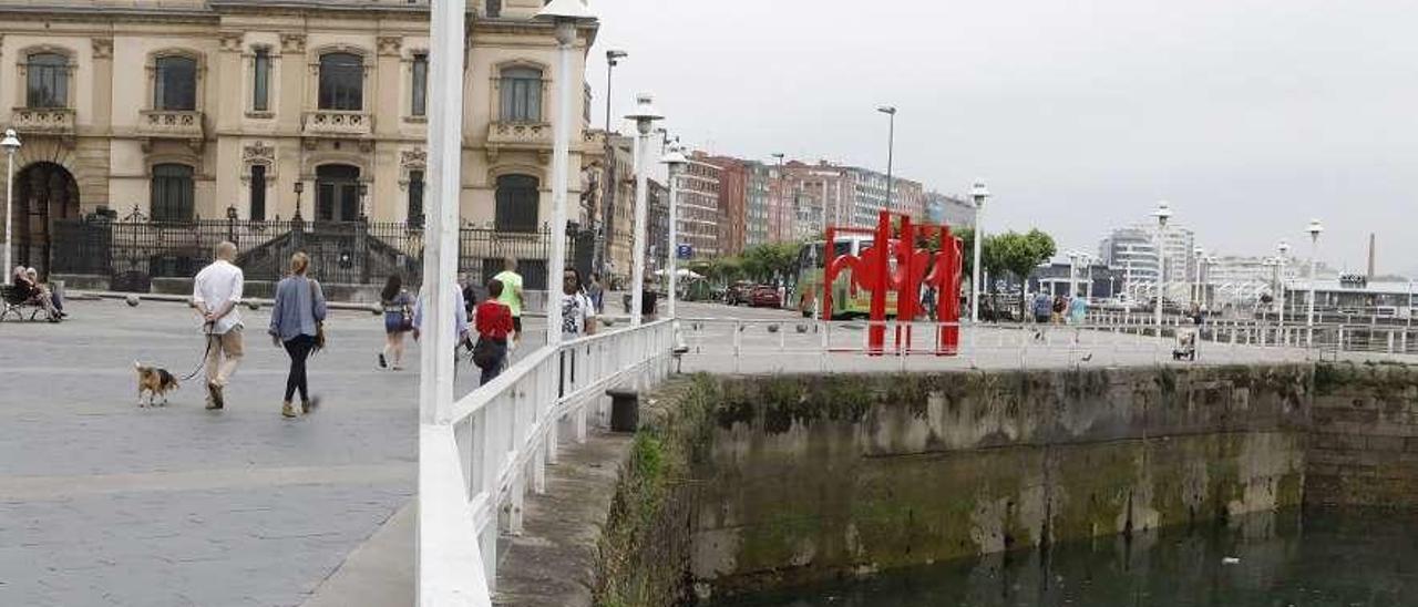 A la derecha, botellas y bolsas tiradas en el agua, en el puerto deportivo de Gijón.