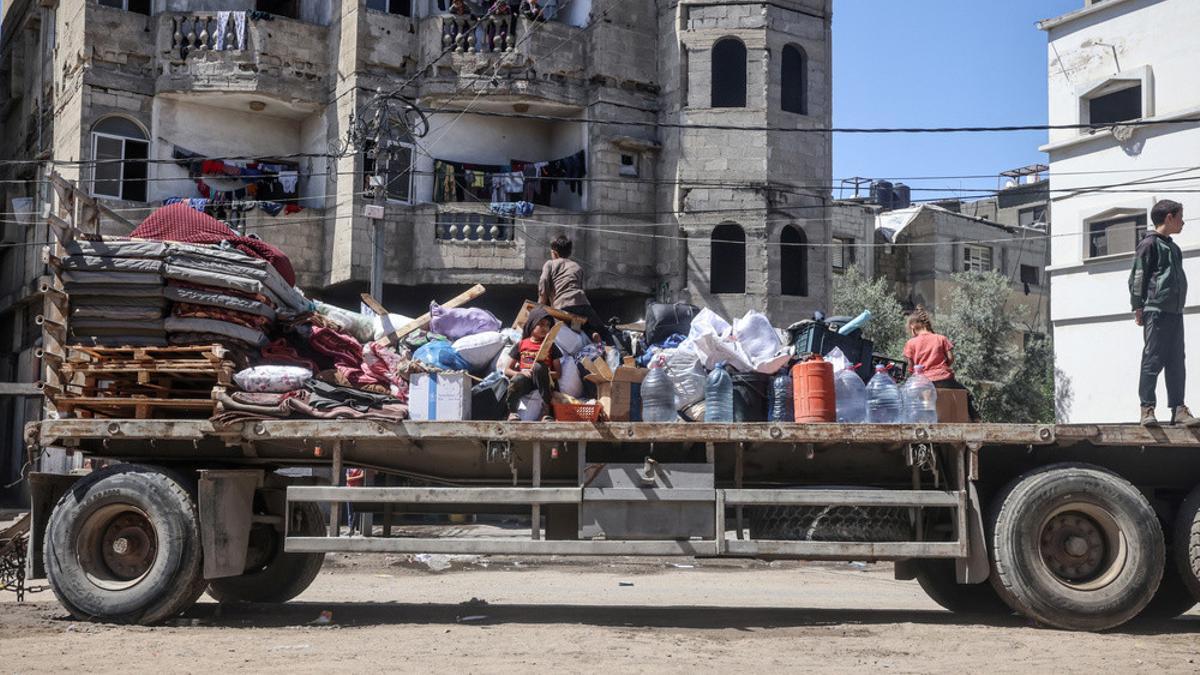 Los palestinos desplazados en Rafá, en el sur de la Franja de Gaza, cargan sus pertenencias cuando salen tras una orden de evacuación del Ejército israelí