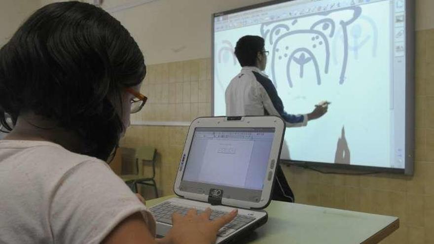 Alumnos con ordenadores y pizarra del programa Abalar.