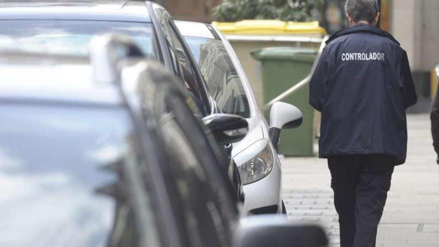 Una controladora de la ORA junto a vehículos en una calle de la ciudad.