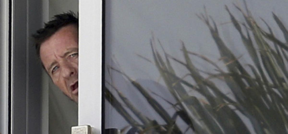 Phil Rudd, el batería de AC/DC, gesticula desde la ventana de su casa en Tauranga, Nueva Zelanda, este miércoles.