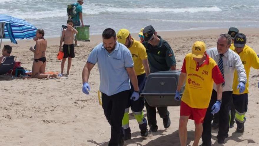 Momento en el que es retirado el cuerpo del bañista, que falleció ayer por la mañana en la playa de El Rebollo.