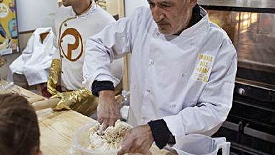 Un cocinero enseña a los niños cómo se realizar una barra de pan.