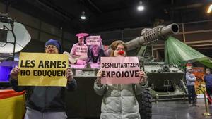 Unos pacifistas rocían pintura rosa sobre una tanqueta en Expojove: Las armas no educan.