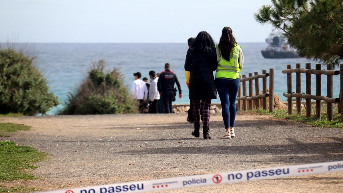 Personal de emergencias detrás del cordón policial en la playa del Miracle de Tarragona