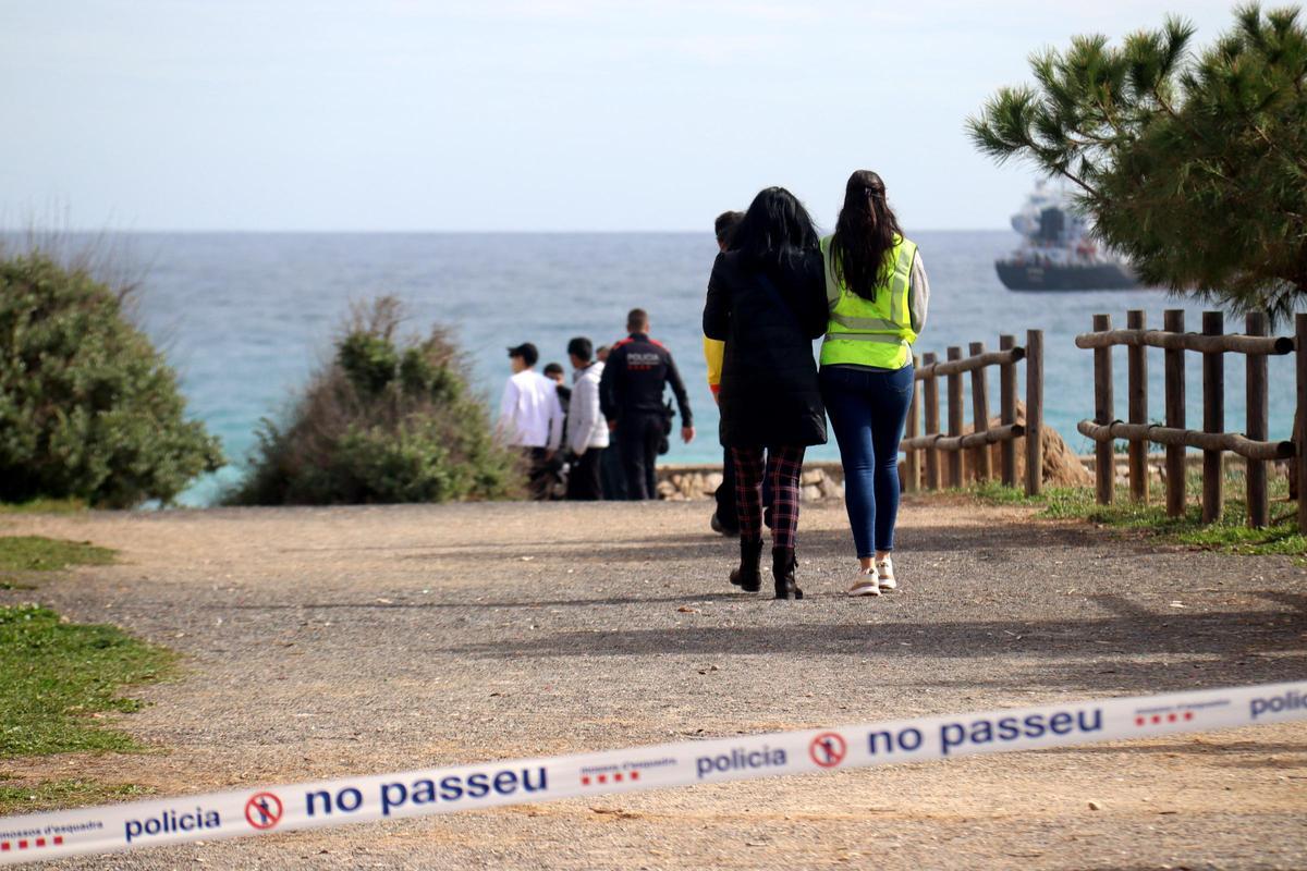 Personal de emergencias detrás del cordón policial en la playa del Miracle de Tarragona