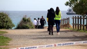 Personal de emergencias detrás del cordón policial en la playa del Miracle de Tarragona
