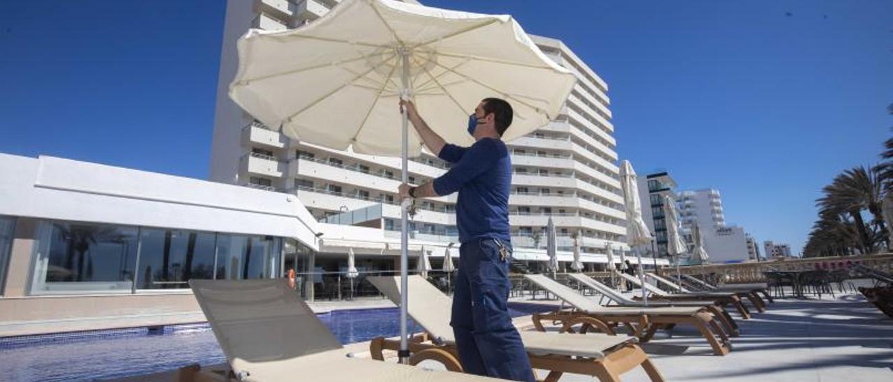 Un trabajador en el área de la piscina en la apertura de un establecimiento, en imagen de archivo.  | GUILLEM BOSCH