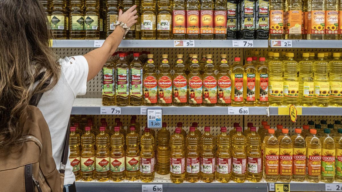 Una dona compra oli en un supermercat, en una imatge d’arxiu.