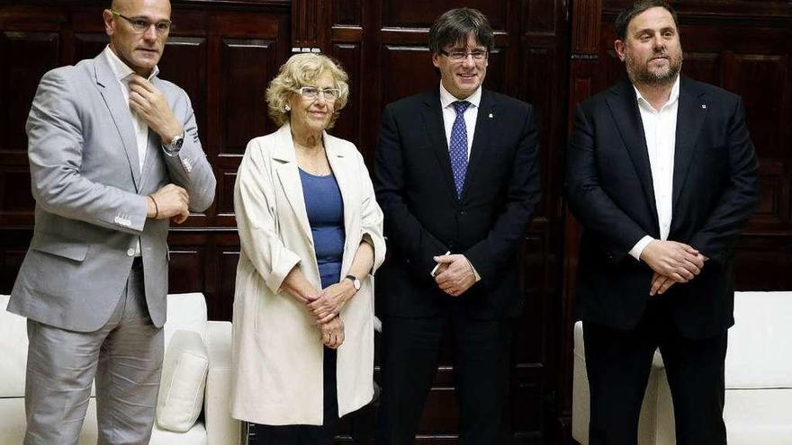 Carmena y Puigdemont (centro), flanqueados por Raül Romeva (izq.) y Oriol Junqueras (dcha.), ayer. // Efe