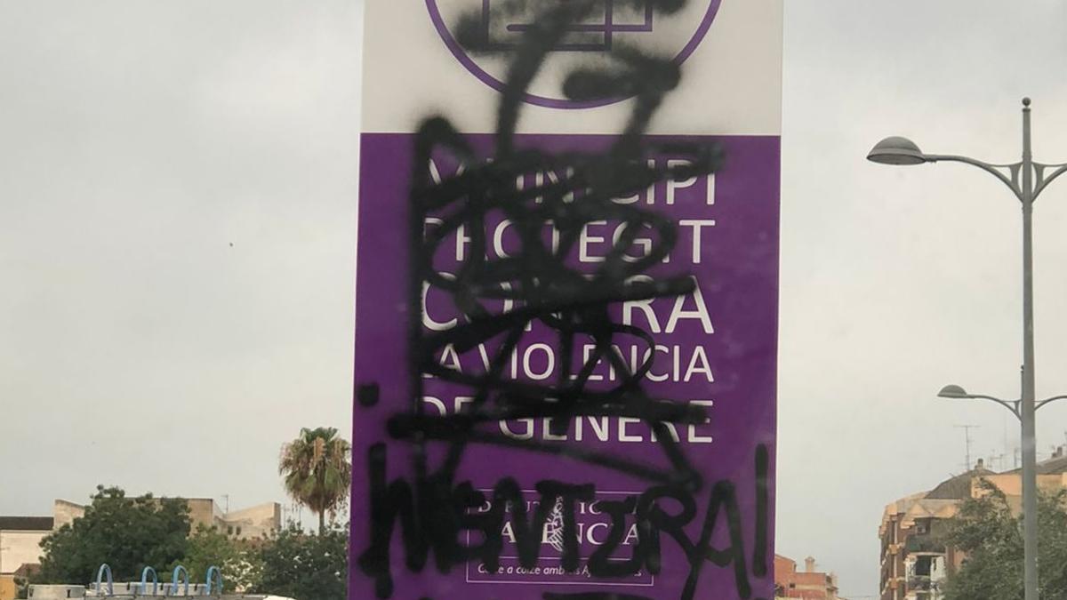 Uno de los carteles vandalizado con spray negro.