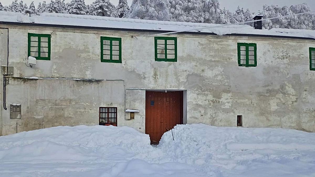 La nieve casi tapa la entrada de una casa en el alto de La Garganta (Villanueva de Oscos).