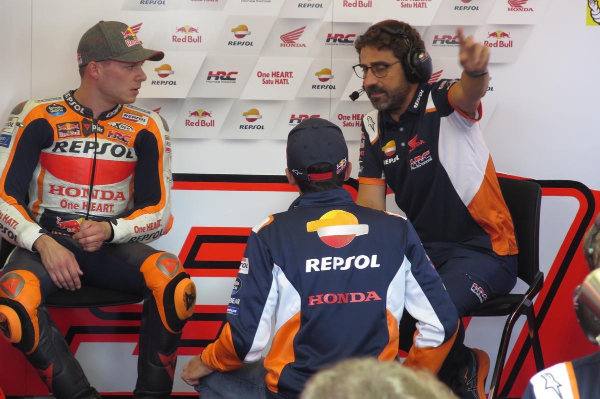 Marc Márquez participa, hoy, en la charla entre Stefan Bradl, a la izquierda, y su ingeniero Santi Hernández, en el boxe del equipo Repsol Honda, en Spielberg.