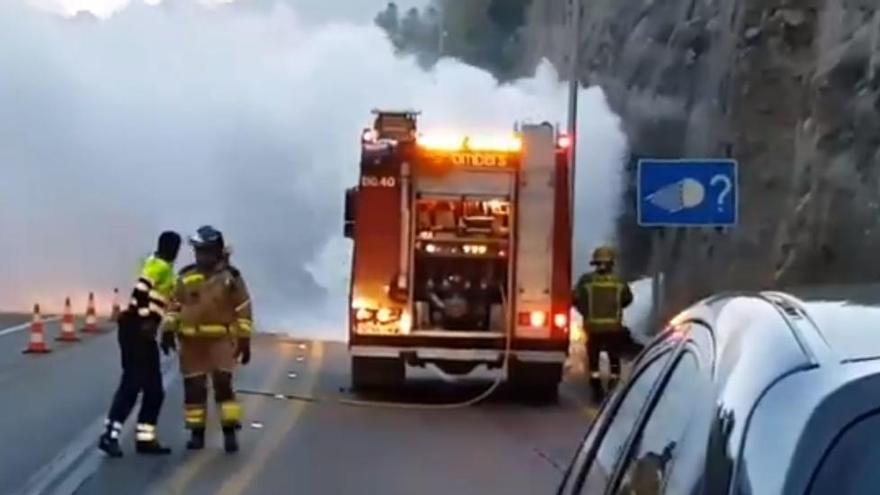 Els Bombers apagant el cotxe incendiat a la C-55, aquest matí.