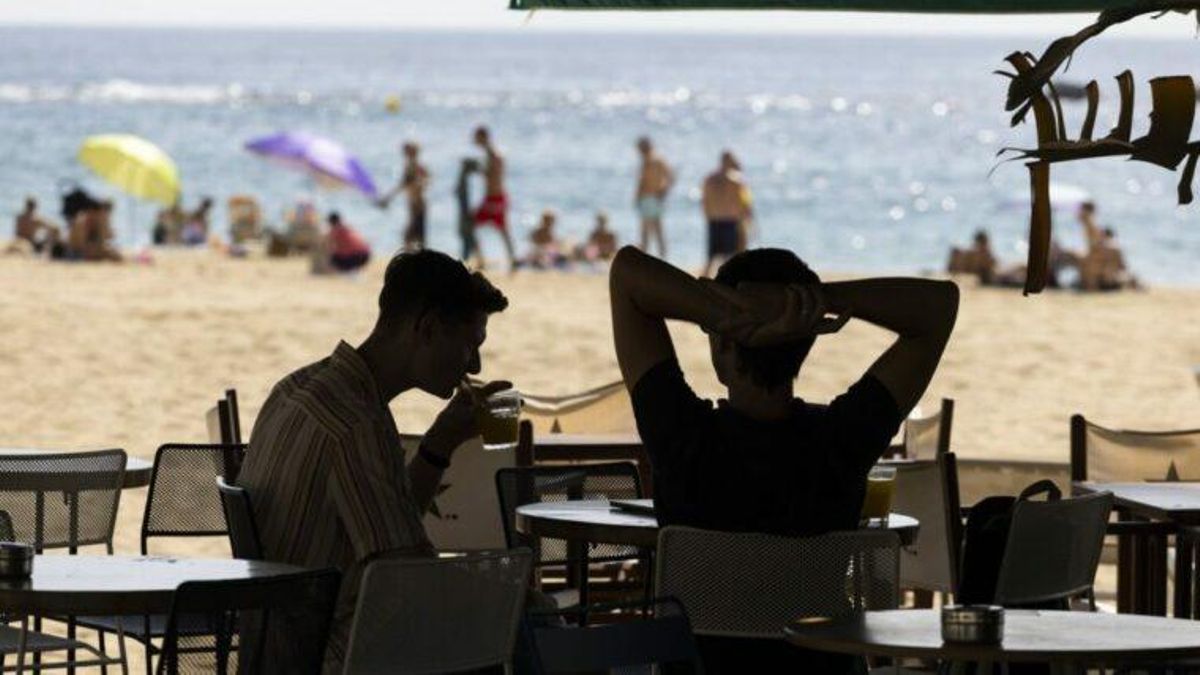 Dos personas sentadas en la terraza de un chiringuito de Barcelona