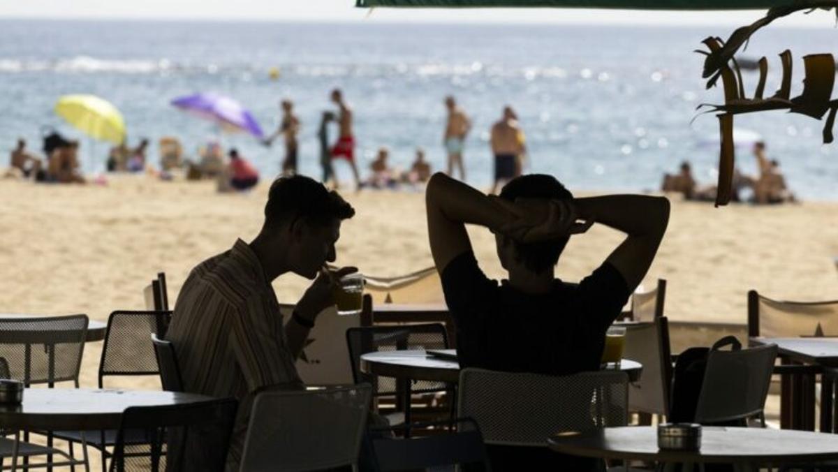 Dos personas sentadas en la terraza de un chiringuito de Barcelona