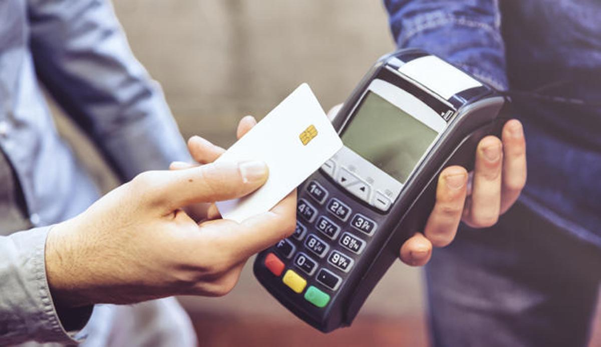 Una persona paga con una tarjeta contactless.