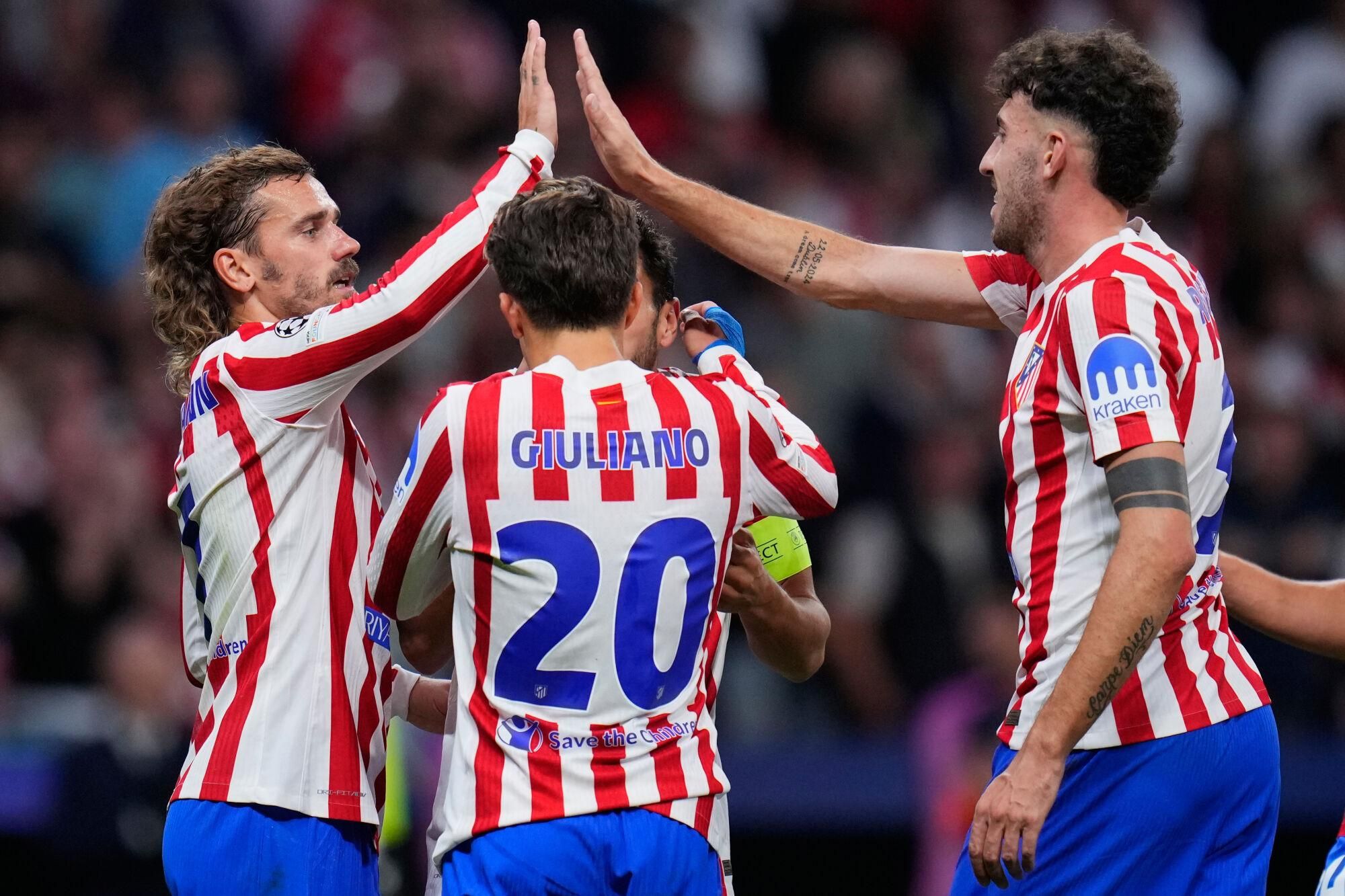 Atletico Madrid's Antoine Griezmann, left, and Matteo Ruggeri celebrate after team mate Giuliano Simeone scored his side's fourth goal during the Champions League opening phase soccer match between Atletico Madrid and Eintracht Frankfurt at the Metropolitano stadium in Madrid, Spain, Tuesday, Sept. 30, 2025. (AP Photo/Manu Fernandez)