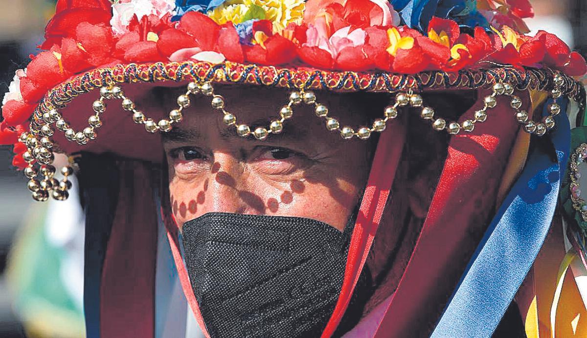 Un fiestero, con sombrero de verdiales y mascarilla.