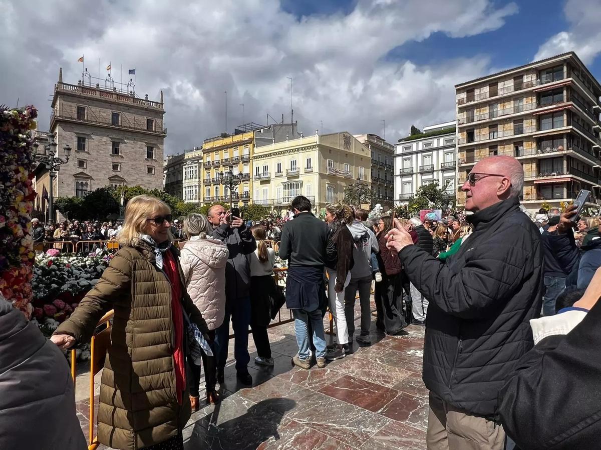 Turistas fotografiándose junto a la Mare de Déu estas Fallas