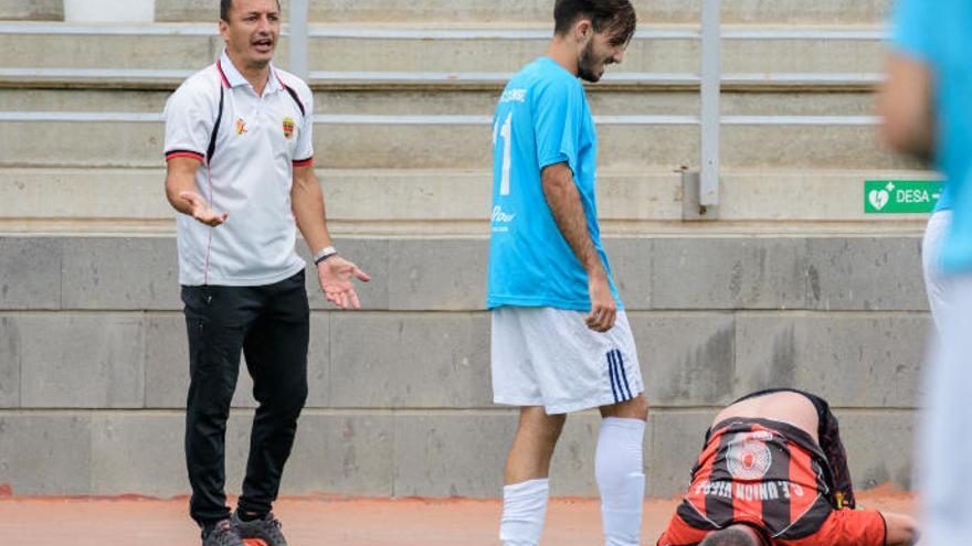 Ángel Luis Camacho pide explicaciones por una dura entrada a uno de sus jugadores durante el partido de la promoción de ascenso entre Unión Viera e Icodense