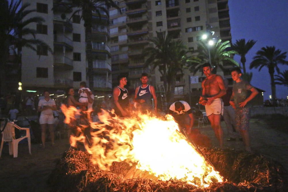 Noche de hogueras, baños, en las playas de la Vega Baja. En las imágenes grupos de amigos y familias en la playa del Cura de Torrevieja