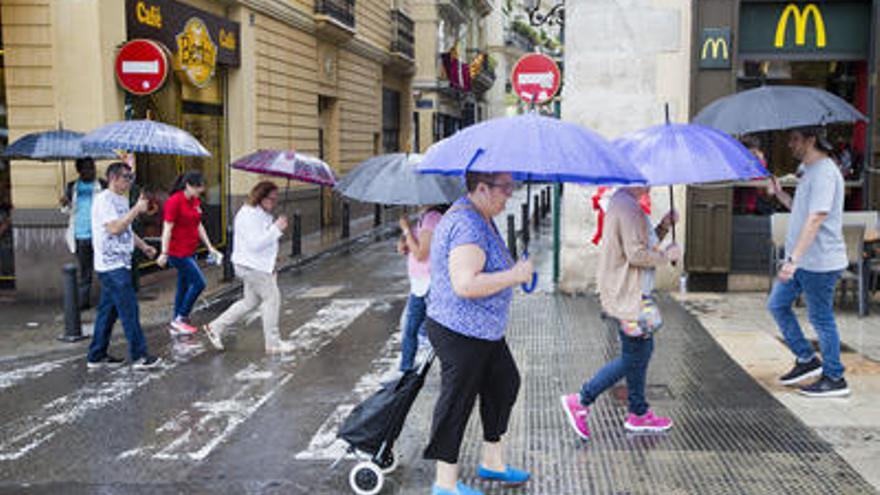 Gente con paraguas, en el centro de València