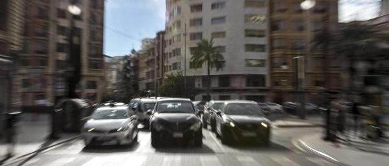 Varios vehículos, circulando en el centro de València.