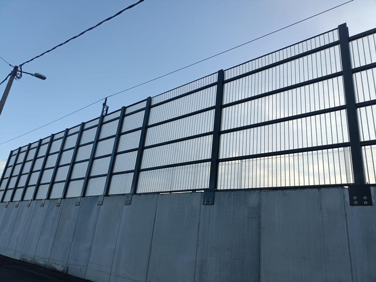 Paneles de metacrilato a lo largo de la vía férrea en Laraño, Santiago.
