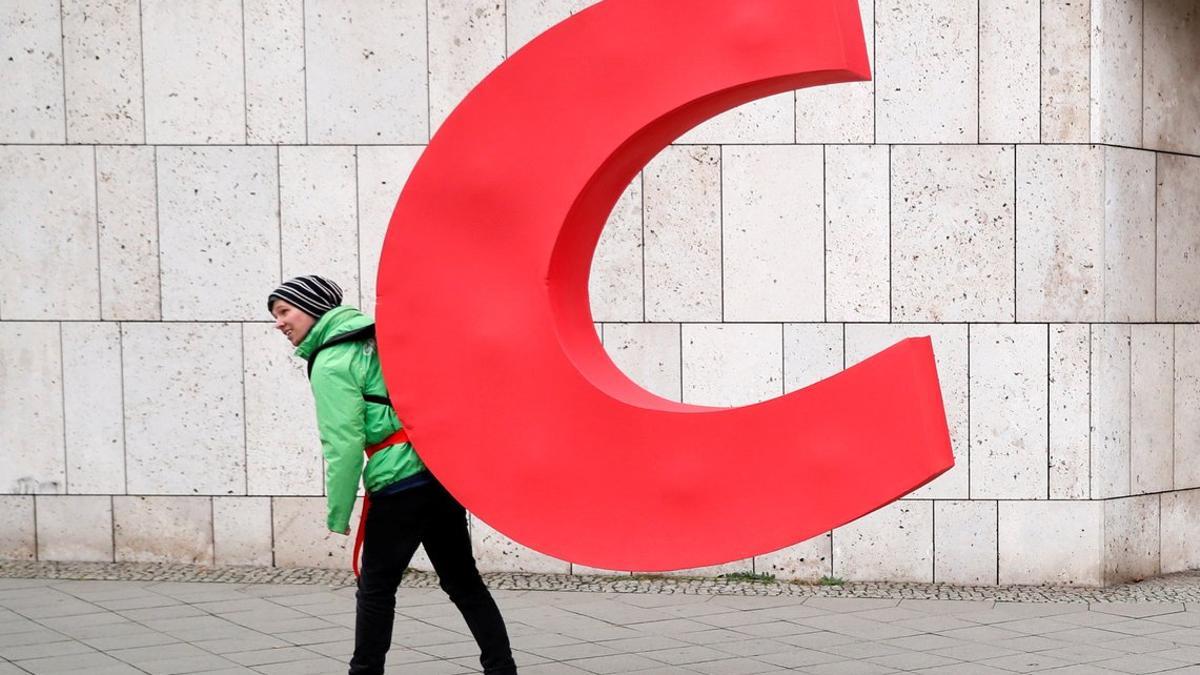 Un activista de Greenpeace se lleva la letra 'C' de la sede de la CDU en Berlín.