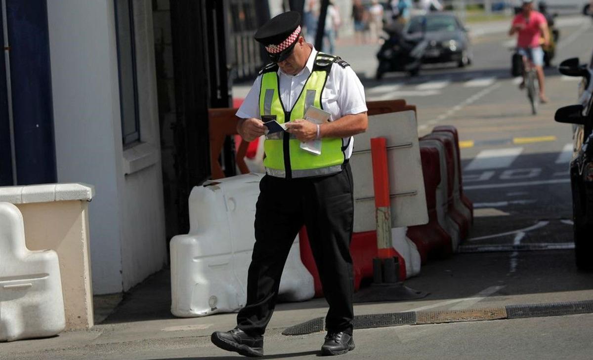 Un oficial de policía de Gibraltar revisa pasaportes en la frontera de Gibraltar con España.