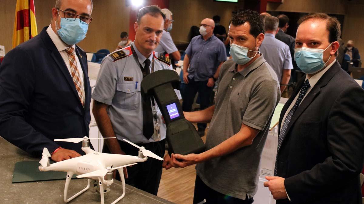 Presentación del sistema de protección antidrones de los Mossos. En la foto, el ’conseller’ Miquel Buch; el director de los Mossos, Pere Ferrer, y el comisario jefe, Eduard Salent, con un técnico que muestra un inhibidor de drones.