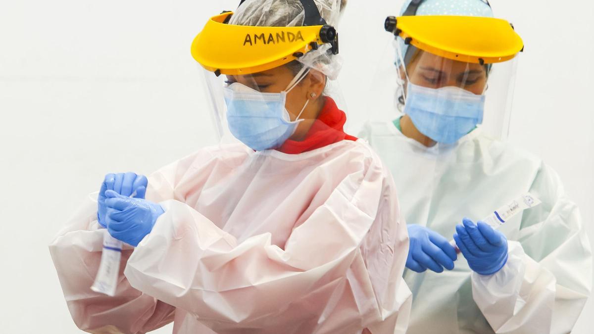 Dos enfermeras realizan pruebas PCR en la carpa situada junto al hospital del Bierzo de Ponferrada.