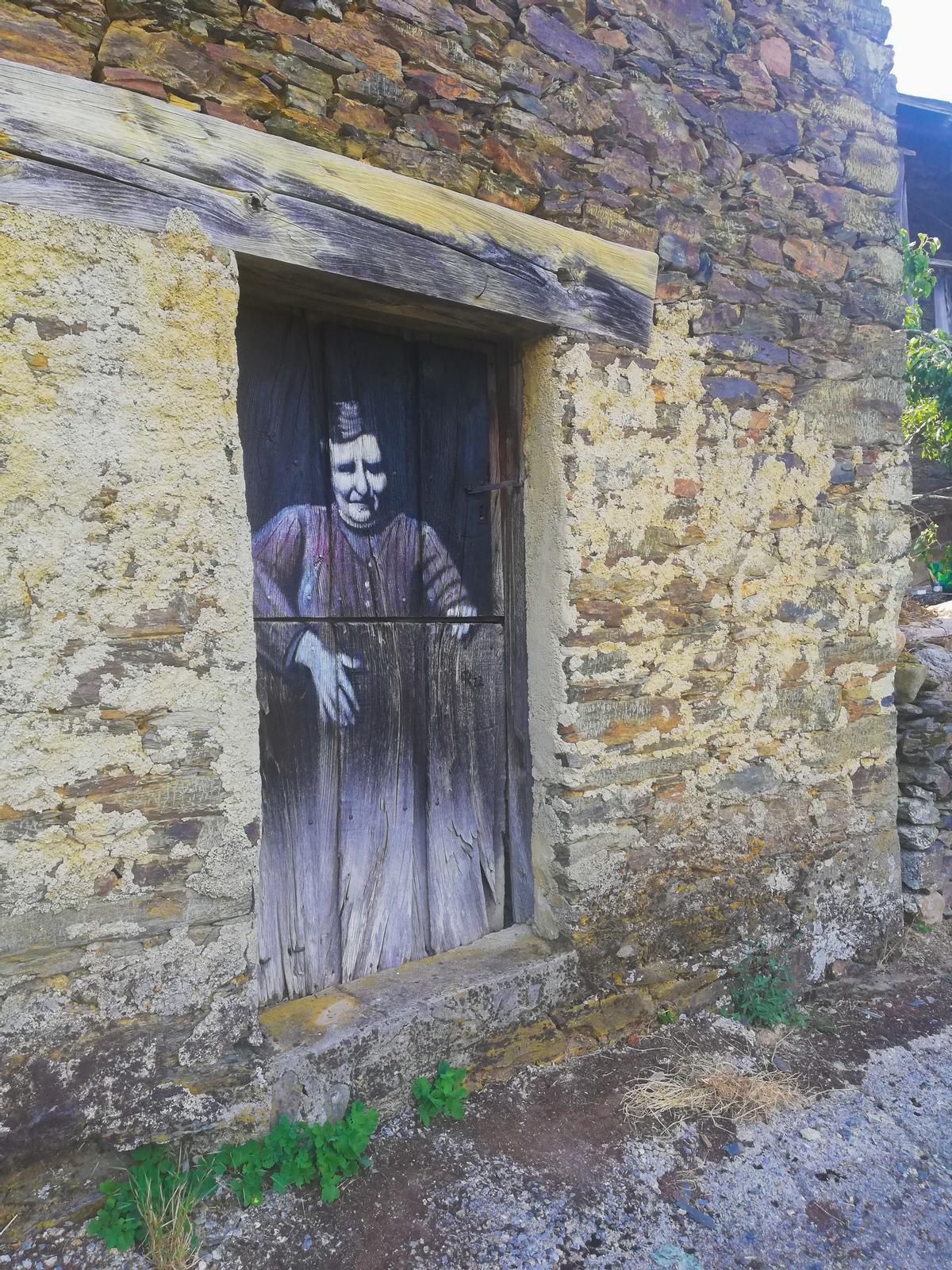 Otra vecina de Valdebóis, reprentada por María del  Roxo en la puerta de una casa del pueblo.