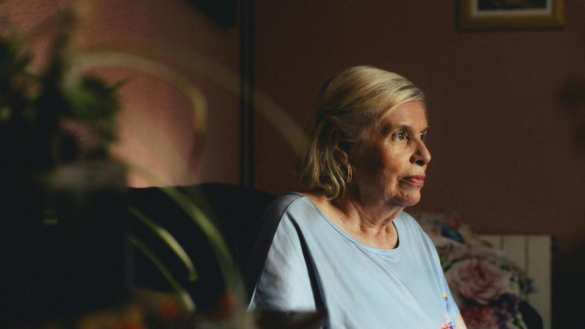 Una mujer mayor sentada sola en su casa.