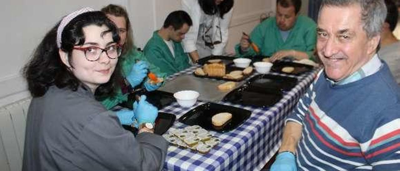 Miembros de Ascívitas ayudan en la preparación de los pinchos.