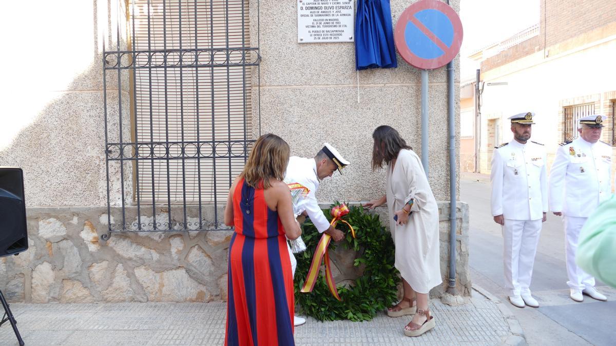 La hija de Domingo Olivo coloca una corona junto a la placa que se ha puesto en honor al Capitán de Navío.
