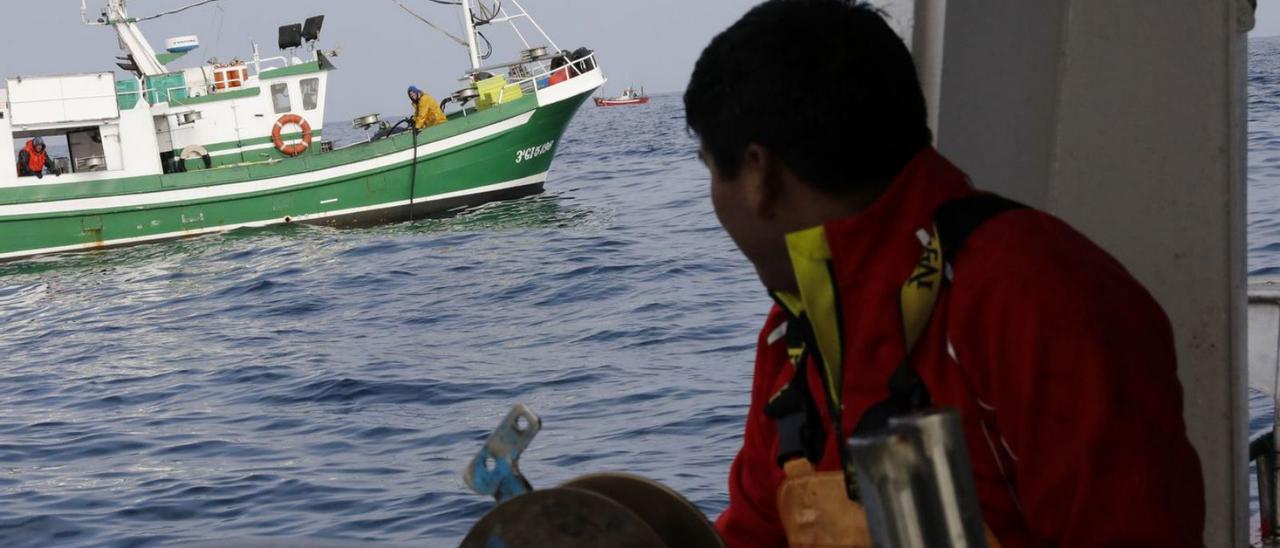 Un pescador observa desde su embarcación el avance de otro barco durante la costera de la xarda en aguas asturianas. | Ángel González