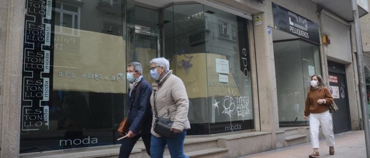 Dos bajos vacíos de una tienda de ropa y de una peluquería en la calle Castelao.  // RAFA VÁZQUEZ