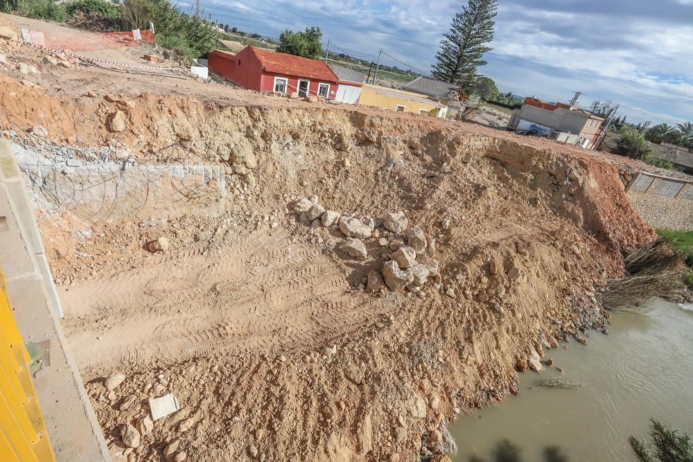 Obras de reparación de la CHS de la mota del río que cedió en Almoradí durante la DANA. Muchas de las zonas afectadas por el paso del agua siguen arrasadas