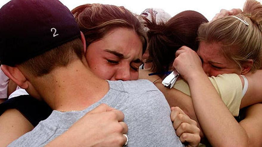 Estudiantes se abrazan tras la matanza de Columbine.