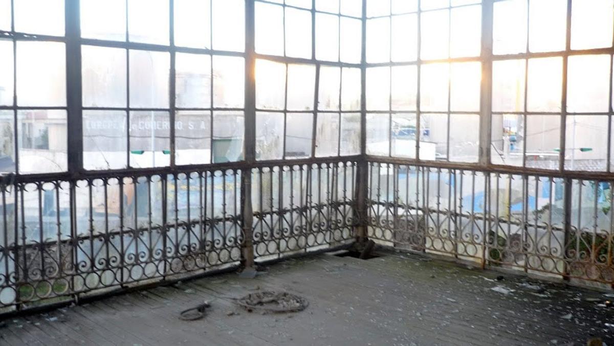 El interior de la galería de la casona, con la cristalera destrozada y el hierro forjado oxidado