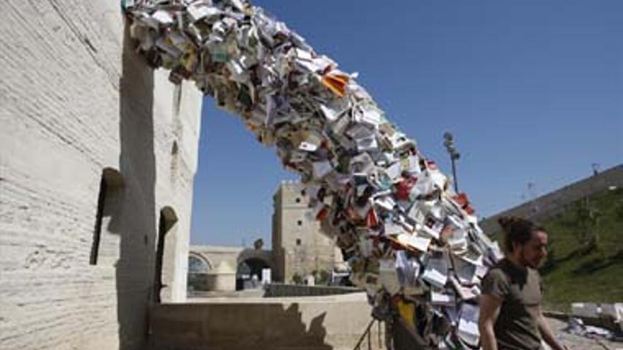 Una escultura de miles de libros &#039;cae&#039; en una orilla del Guadalquivir