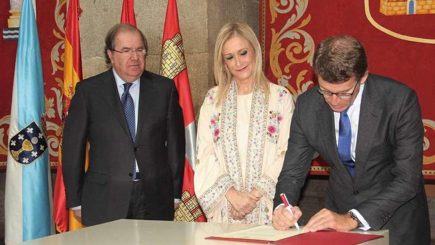 Feijóo firma la declaración ante los presidentes de Madrid (centro) y Castilla y León. // FdV